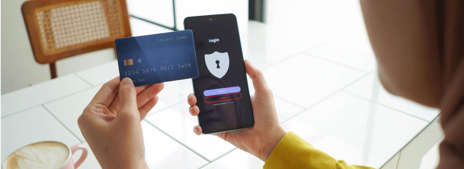 person holding credit card and cell phone checking secure login