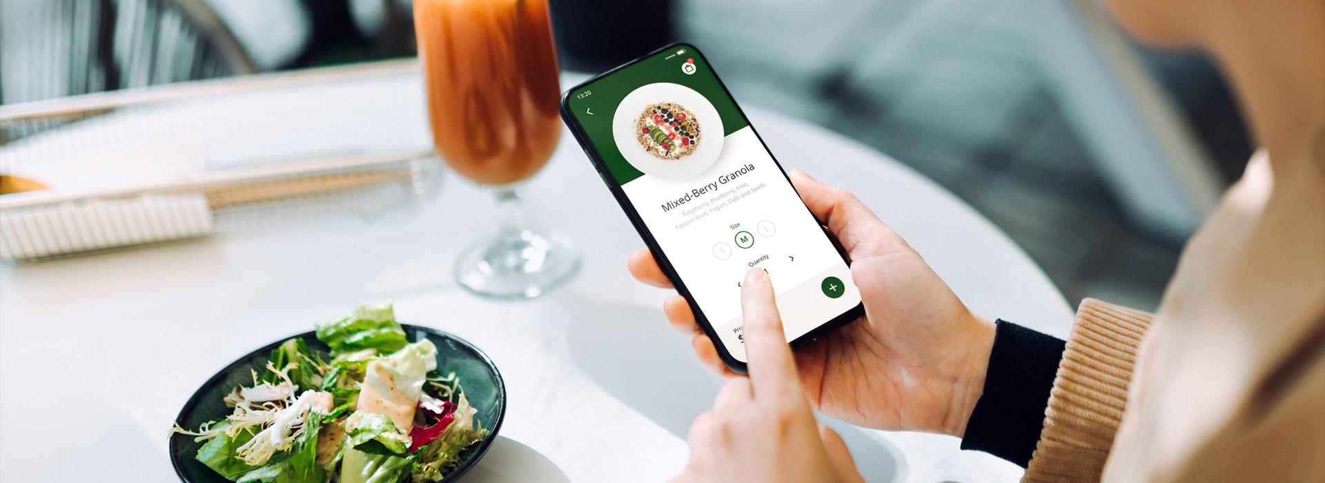 hand holding phone at dinner table